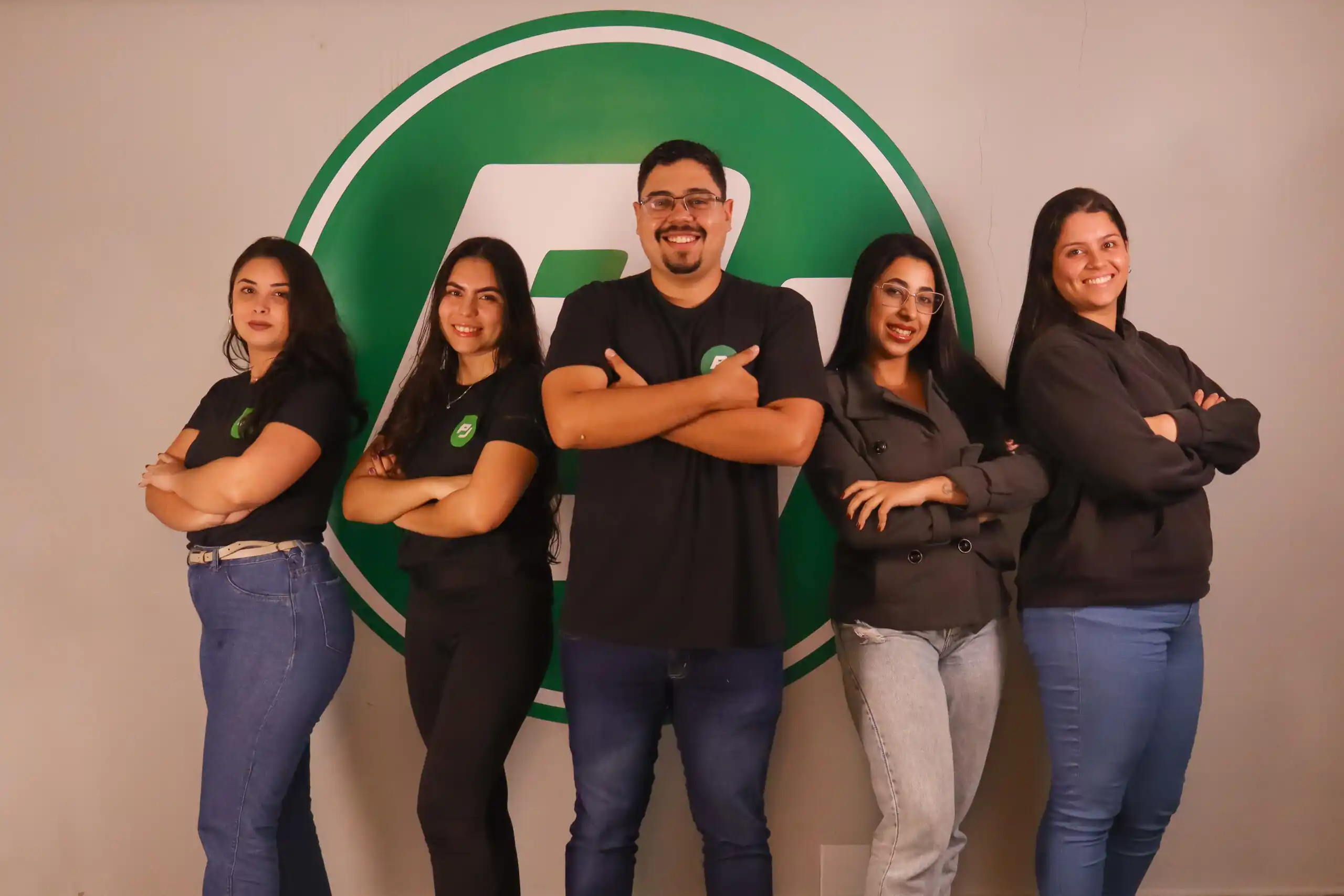 Equipe da Contrato PJ Serviços em frente ao logo da empresa