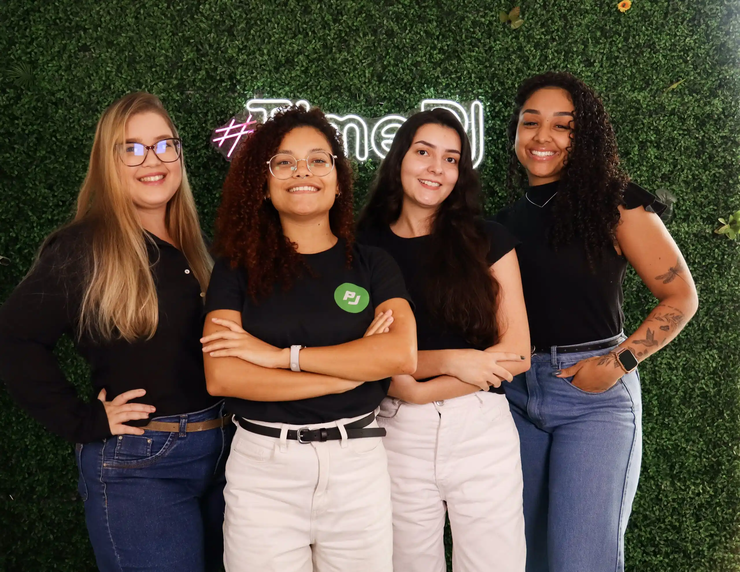 Meninas do time de folha de pagamento em frente ao neon